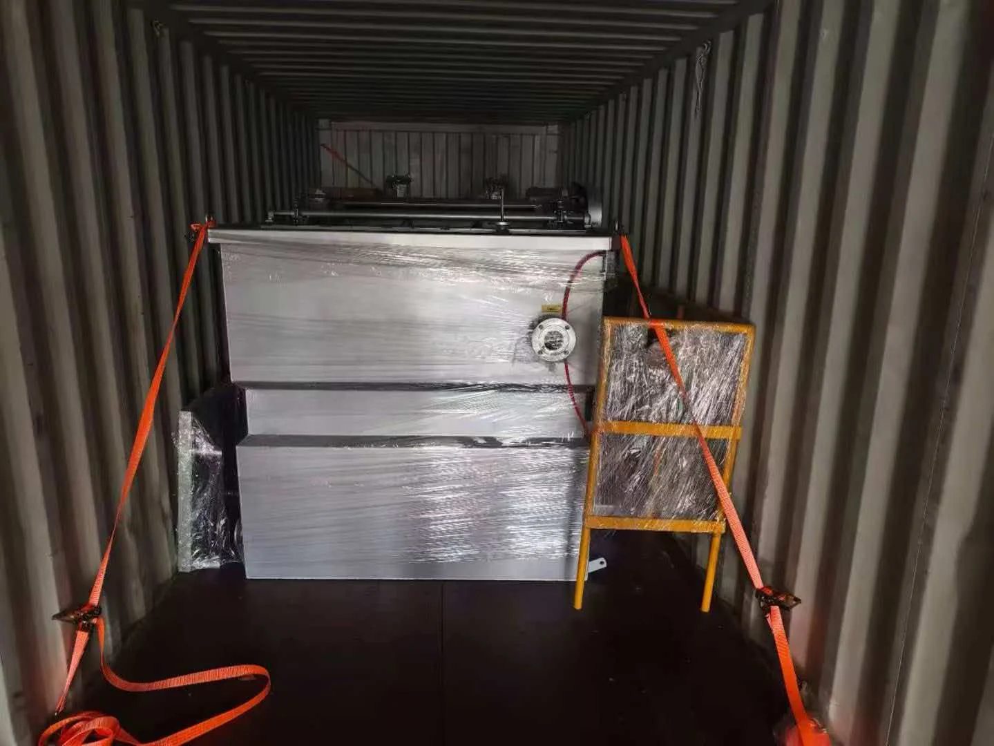 Wrapped equipment secured inside a shipping container